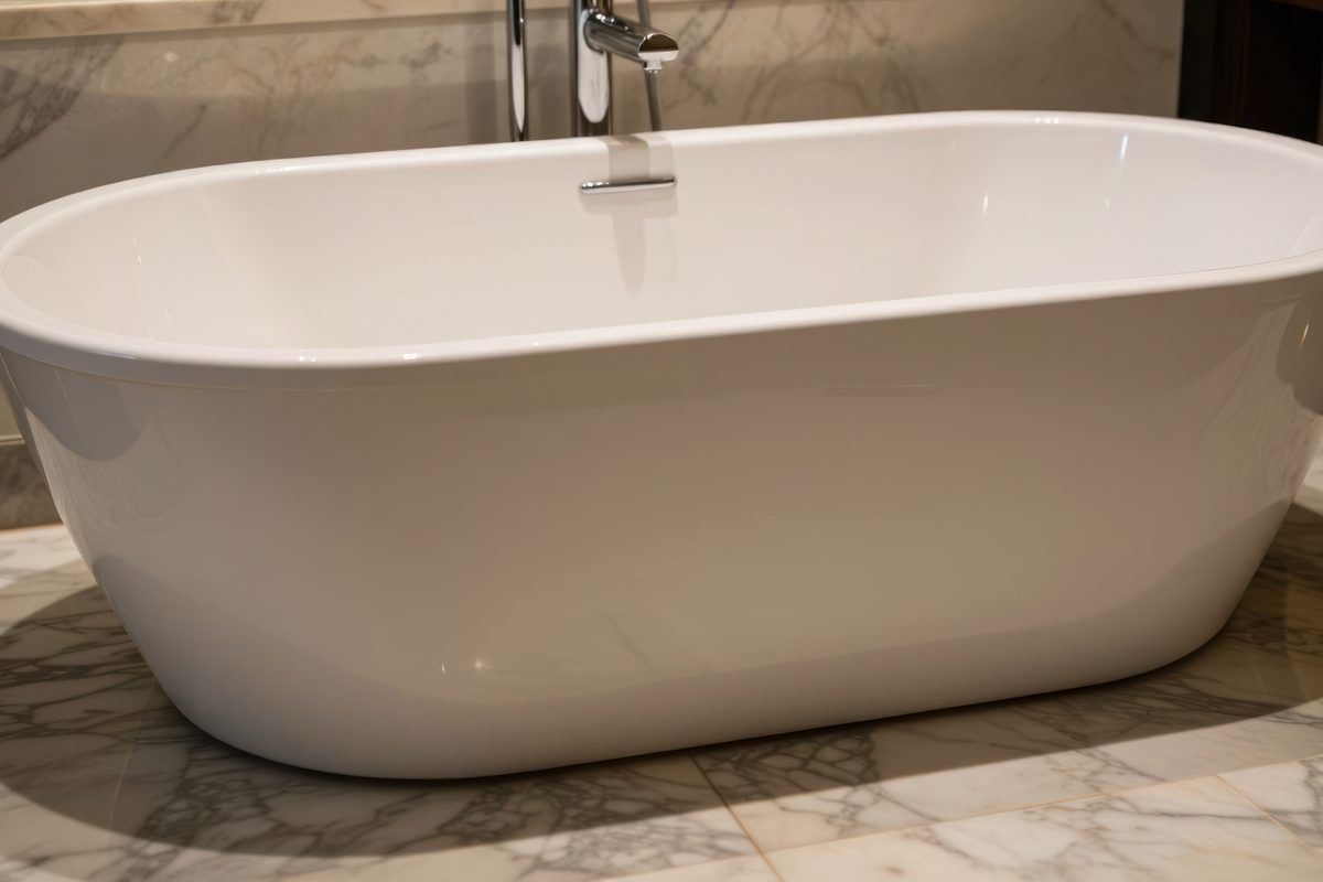 Large white bath standing in a bathroom